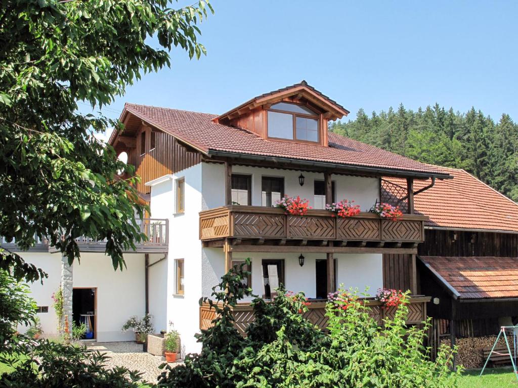 a house with a balcony with flowers on it at Apartment Kühbeck-2 by Interhome in Bischofsmais