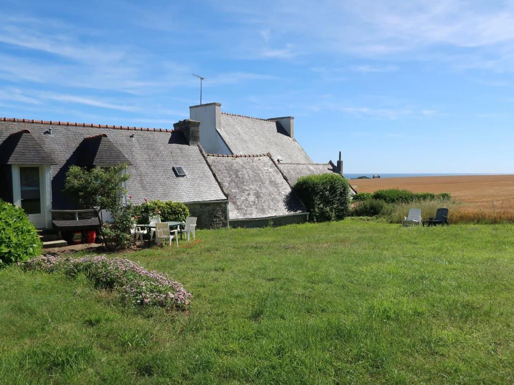 an old house on a field with a grass yard at Holiday Home Les Blés by Interhome in Plozévet