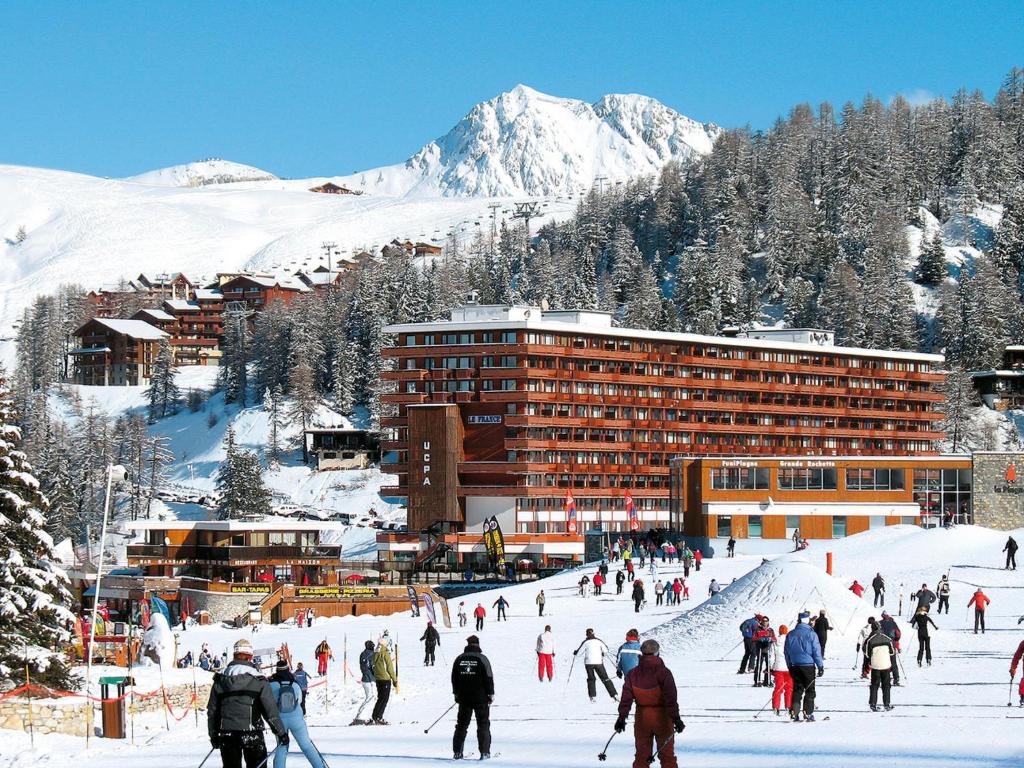 a group of people skiing in the snow in front of a hotel at Apartment Plagne Centre 1 - LAP170 by Interhome in La Plagne