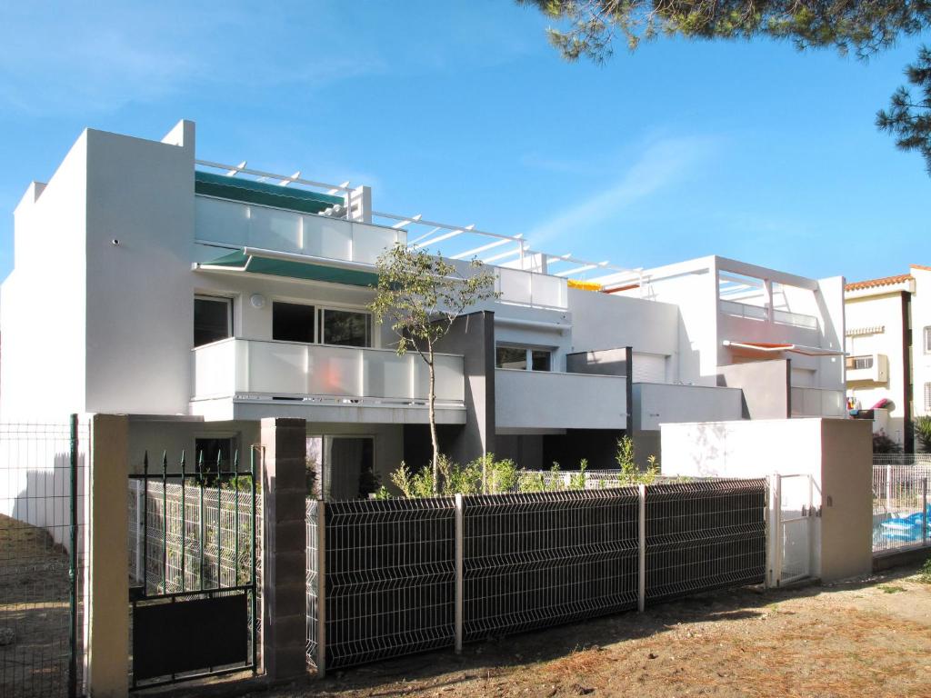 une maison blanche avec une clôture devant elle dans l'établissement Apartment Les Pins Parasols - AGL350 by Interhome, à Argelès-sur-Mer