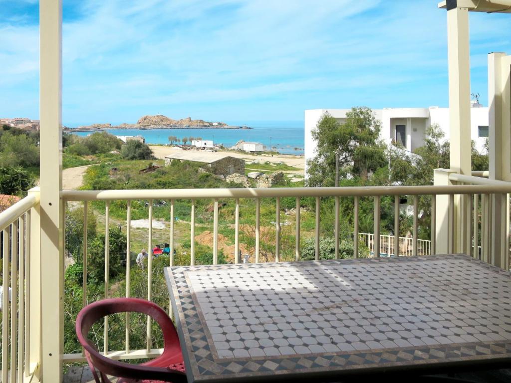balcone con tavolo, sedia e vista sull'oceano di Apartment Résidence de la Plage-2 by Interhome a LʼÎle-Rousse