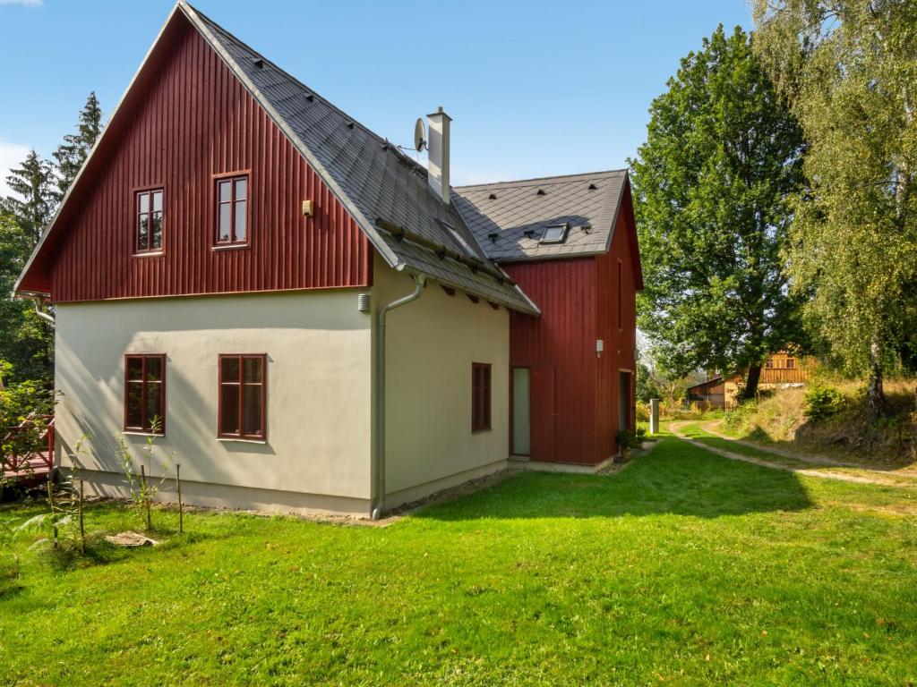 czerwono-biały dom z zielonym dziedzińcem w obiekcie Studio Na mechu-1 by Interhome w mieście Mezná