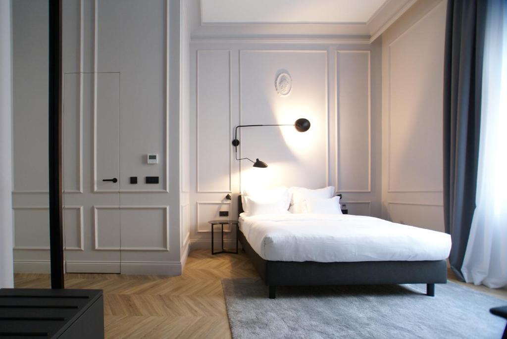 a white bedroom with a bed and a lamp at Fingerprint Luxury Apartments 2 in Zagreb