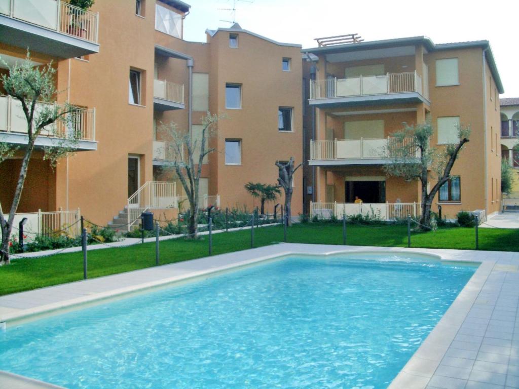 a swimming pool in front of an apartment building at Apartment Il Piccolo by Interhome in Toscolano Maderno