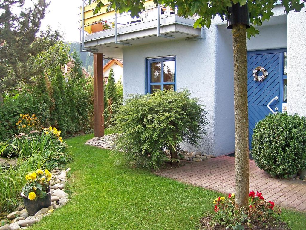 ein Haus mit einem Balkon und einem Garten mit Blumen in der Unterkunft Apartment Brombeerweg by Interhome in Unterkirnach