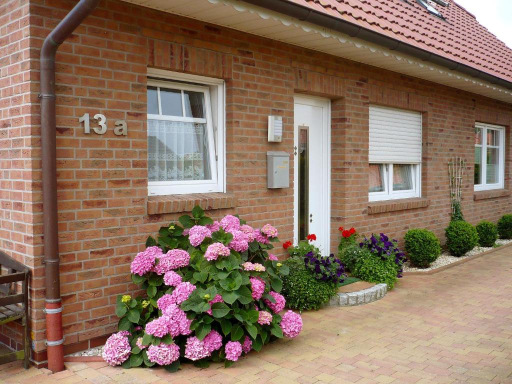 dom z kwiatami przed nim w obiekcie Holiday Home Reissmann by Interhome w mieście Norden