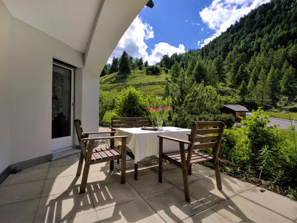a table and chairs on a patio with a view at Apartment Chesa Flora 53 by Interhome in St. Moritz
