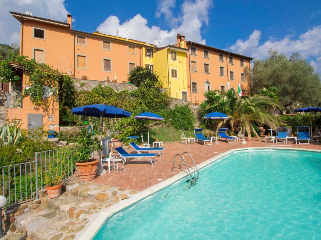 un hotel con piscina con sedie e ombrelloni di Holiday Home Bruna by Interhome a Massarosa