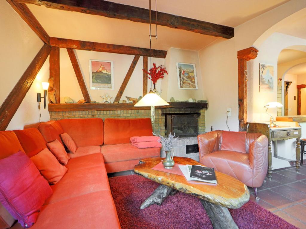 a living room with a red couch and a table at Apartment Bodmen A by Interhome in Zermatt