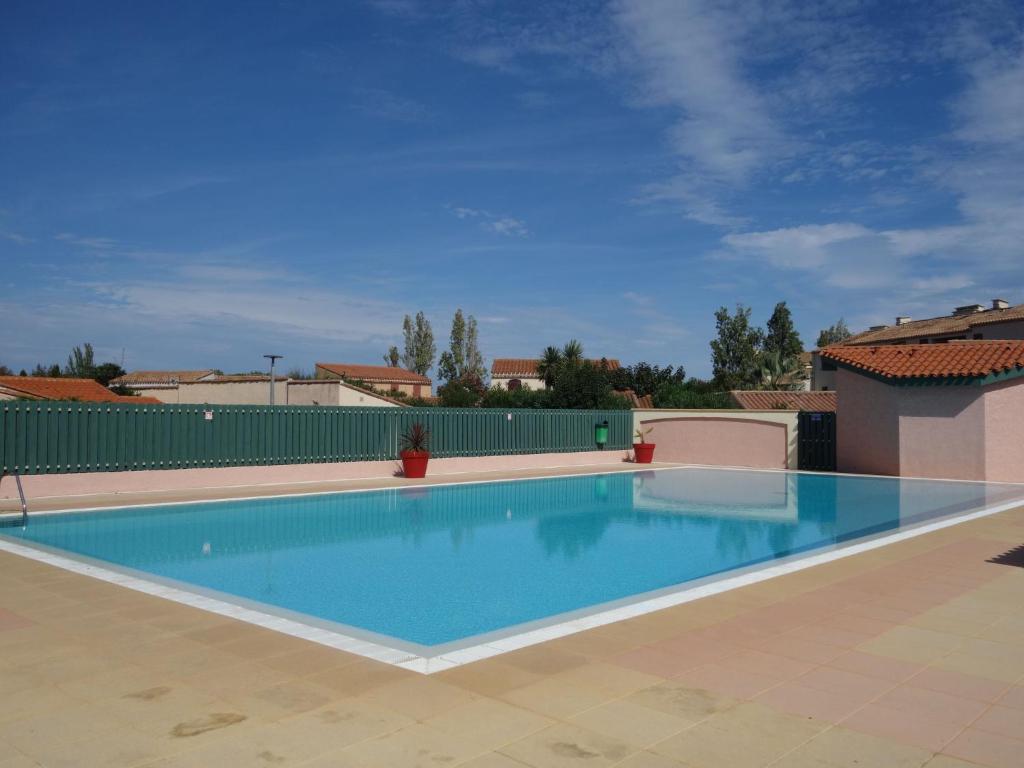 a large swimming pool with blue water at Holiday Home Le Hameau des Capellans by Interhome in Saint-Cyprien-Plage