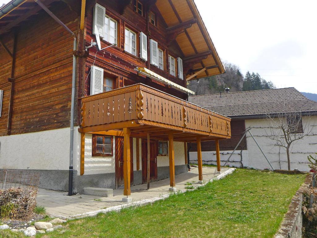 ein Holzgebäude mit einem Balkon auf der Vorderseite in der Unterkunft Chalet Höfli by Interhome in Jaun