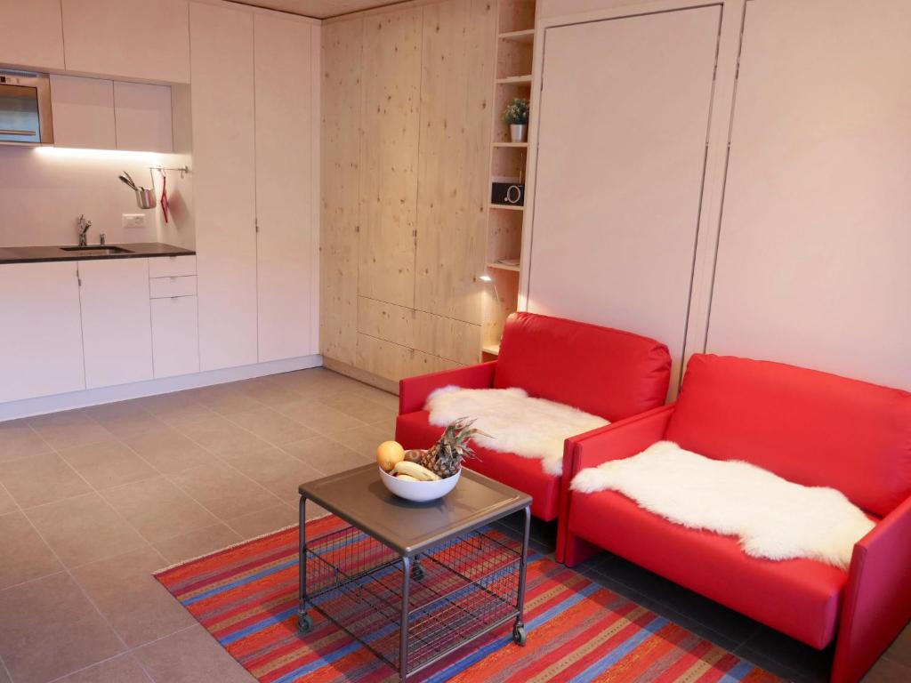 a living room with two red couches and a table at Apartment Rosablanche D52 by Interhome in Siviez