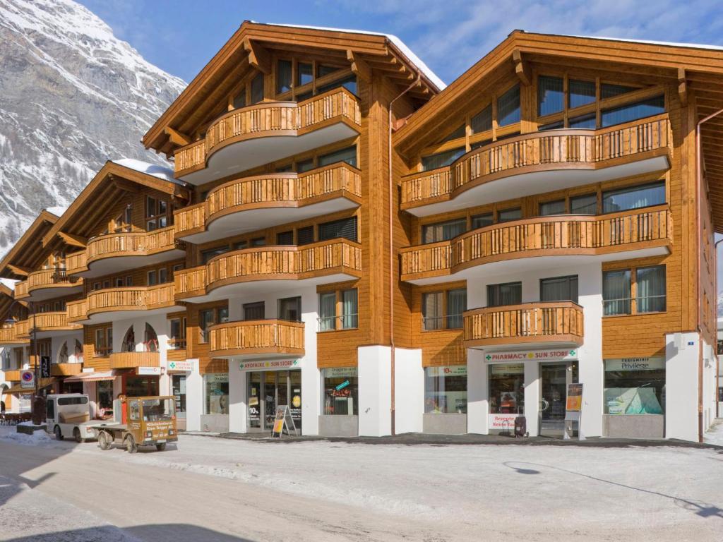 un gran edificio de madera con una montaña cubierta de nieve en Apartment Zur Matte B-1 by Interhome, en Zermatt