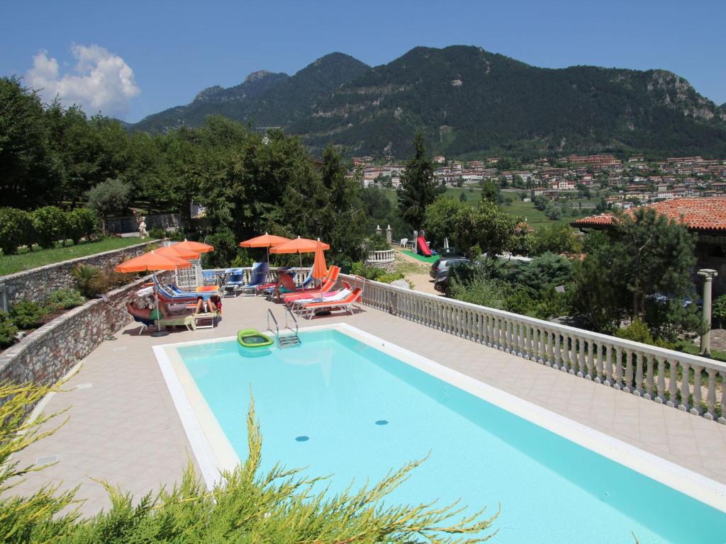una piscina con sillas y sombrillas en un complejo en Apartment La Tartufaia-4 by Interhome, en Tremosine Sul Garda
