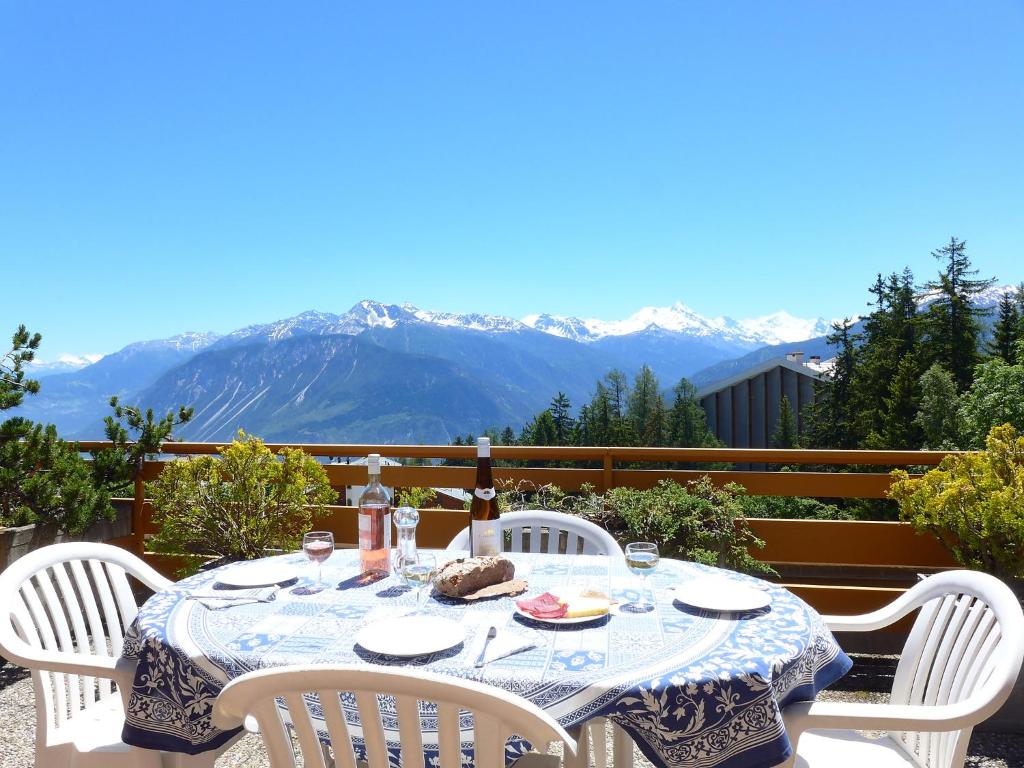 una mesa con sillas blancas y una mesa con comida. en Apartment Terrasse des Alpes-8 by Interhome, en Vermala