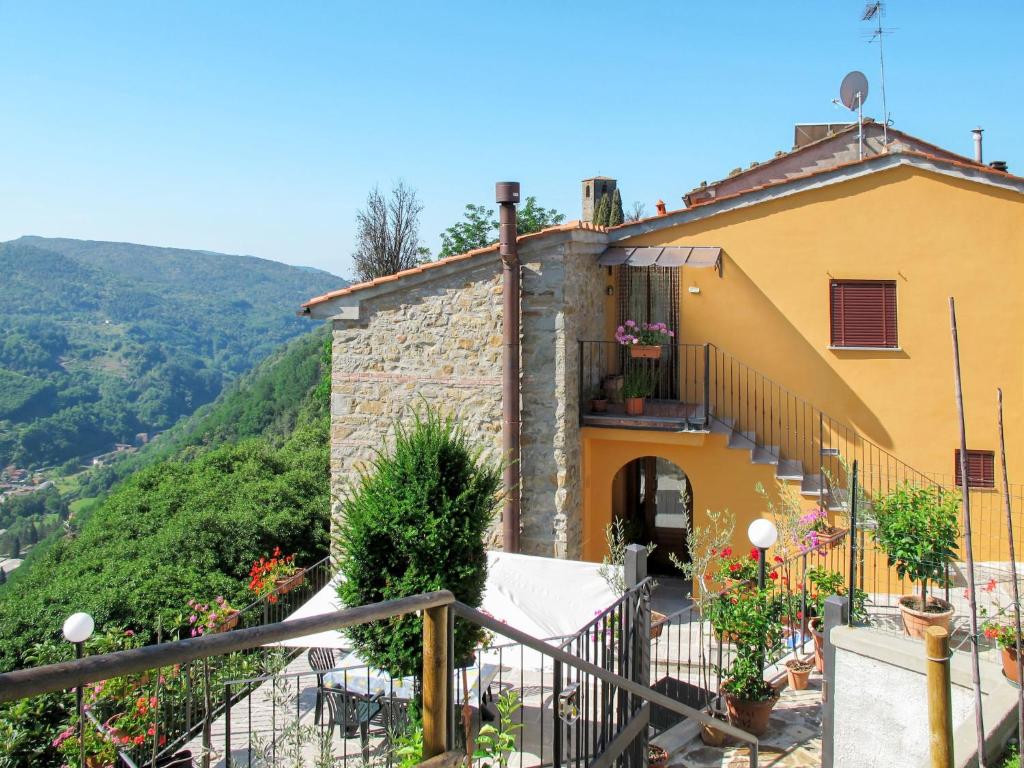 a yellow building with a balcony and a hill at Apartment Poggetto 1 by Interhome in Vellano