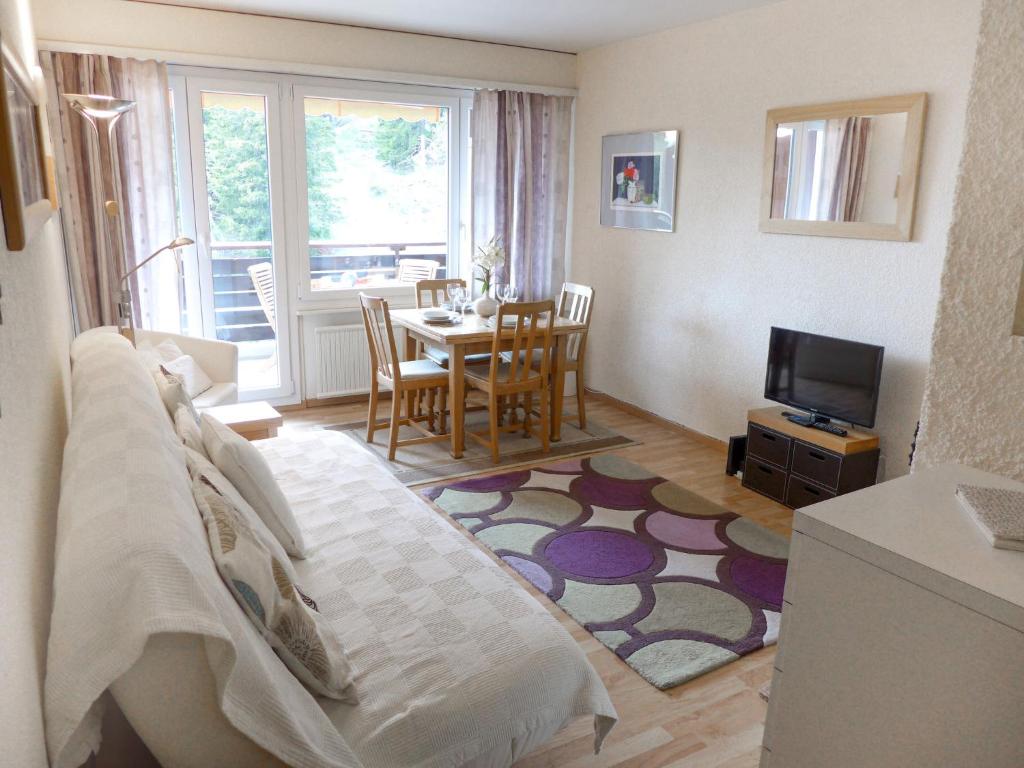 a living room with a couch and a table with a television at Apartment Les Choucas B by Interhome in Vermala