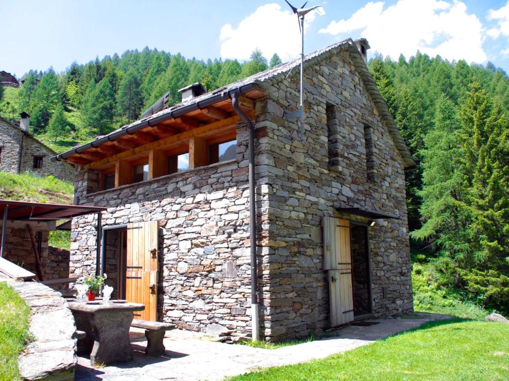 Alpe di ScieruにあるHoliday Home Dara Cotta by Interhomeの森の木の扉のある石造りの家