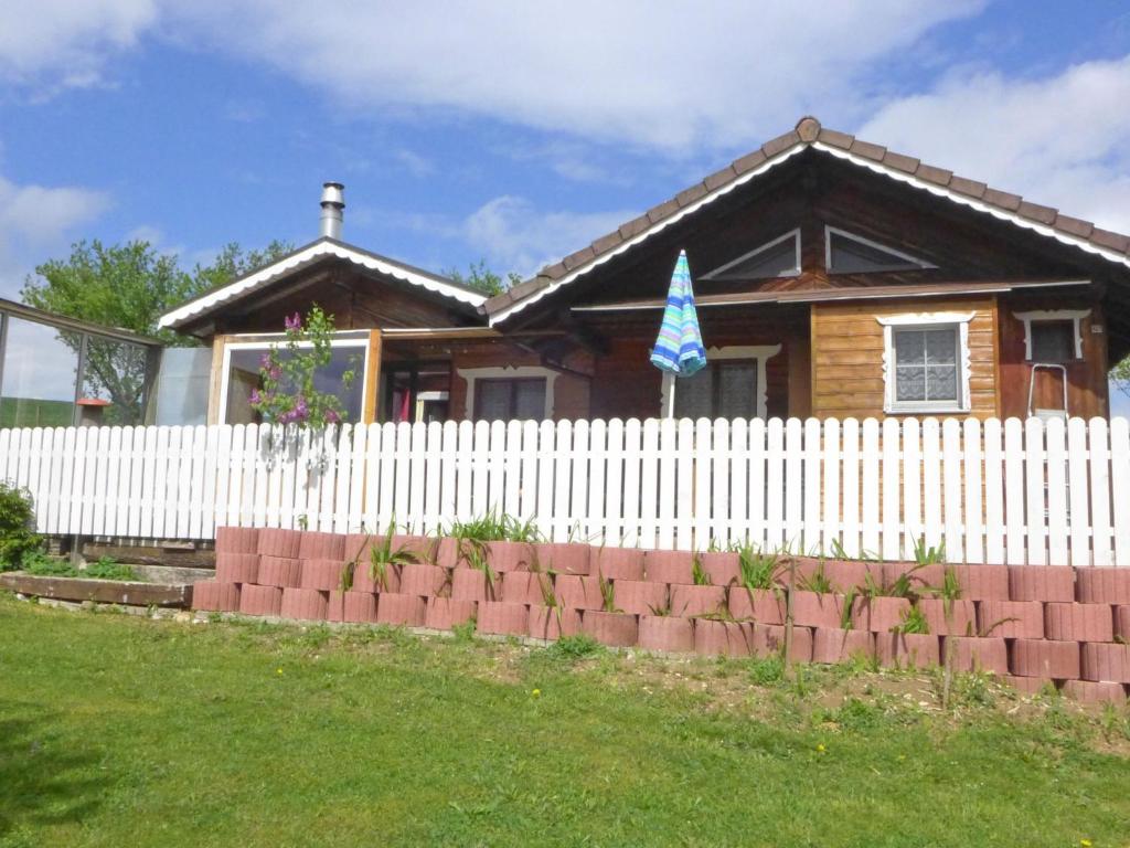 ein Haus hinter einem weißen Gartenzaun in der Unterkunft Chalet Hügli by Interhome in Bure