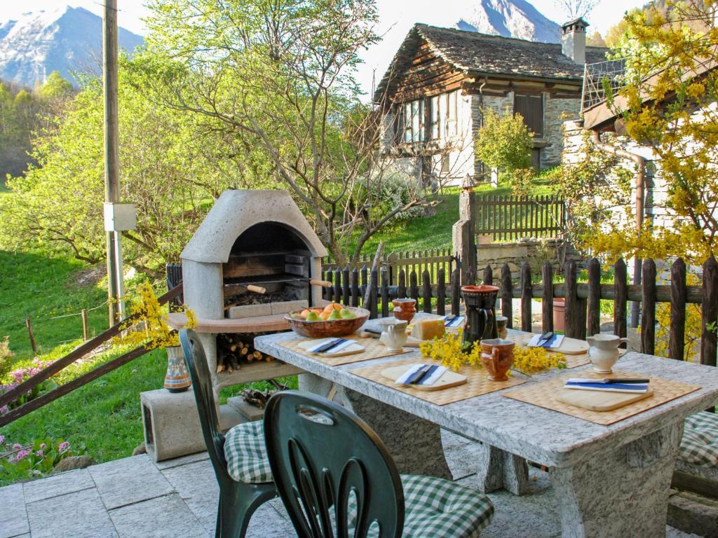 a table and chairs with a pizza oven in a yard at Holiday Home Marianne by Interhome in Aquila