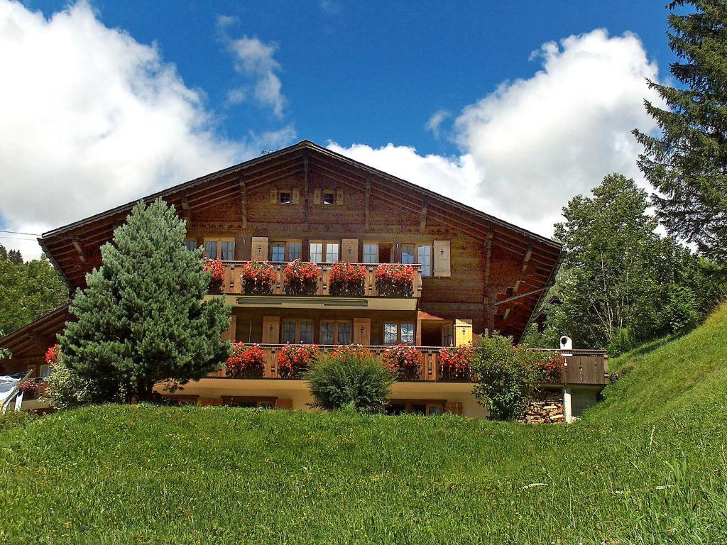 a large house with a balcony on a hill at Apartment Chalet Doris-1 by Interhome in Grindelwald