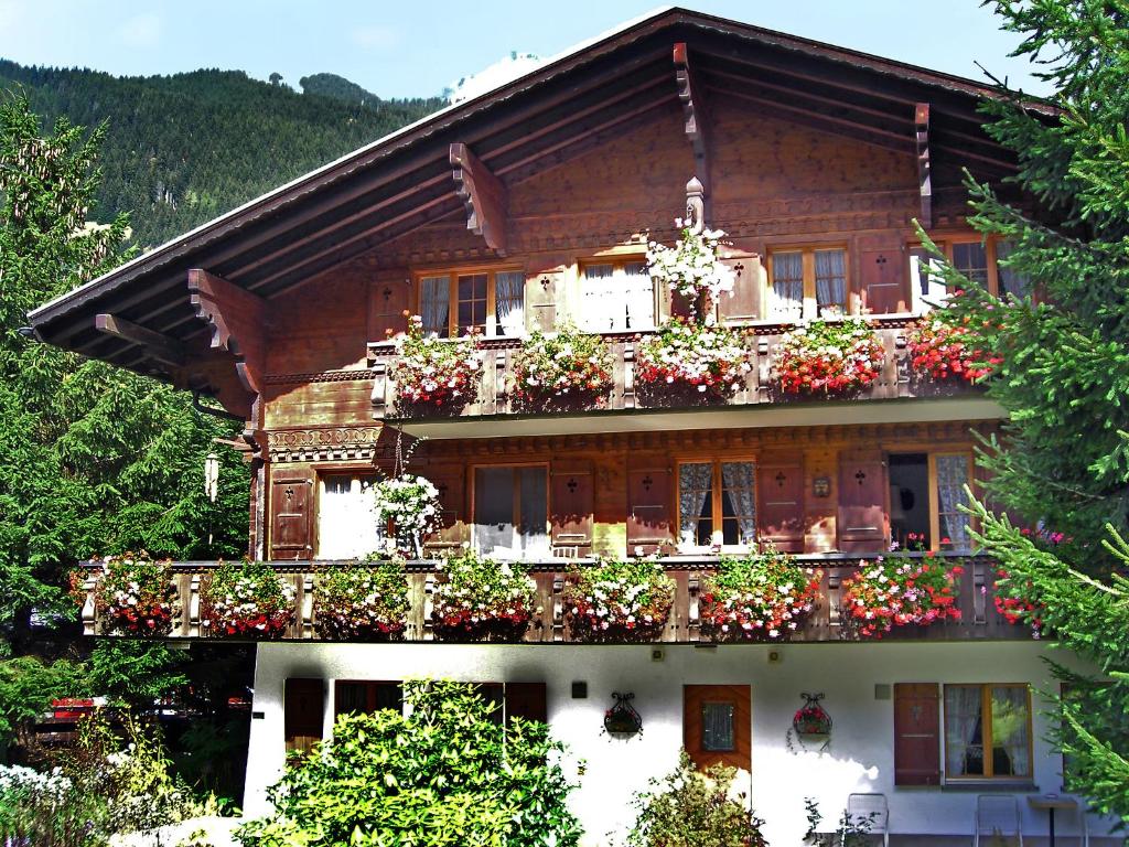 Una casa con flores en el balcón. en Apartment Chalet Marie Rosa-3 by Interhome, en Grindelwald