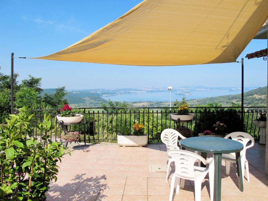 een patio met een blauwe tafel en witte stoelen bij Holiday Home Casa Martina by Interhome in Montefiascone