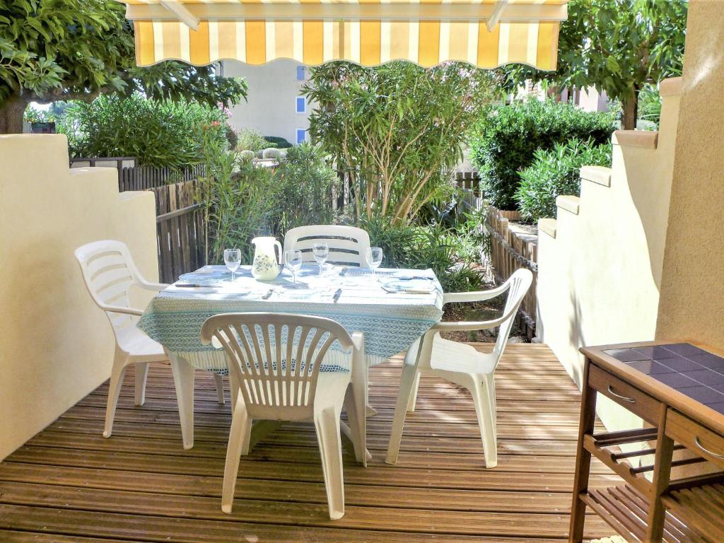 濱海聖皮埃爾的住宿－Apartment Les Terrasses de la Méditérranée-1 by Interhome，木甲板上配有桌椅和桌椅