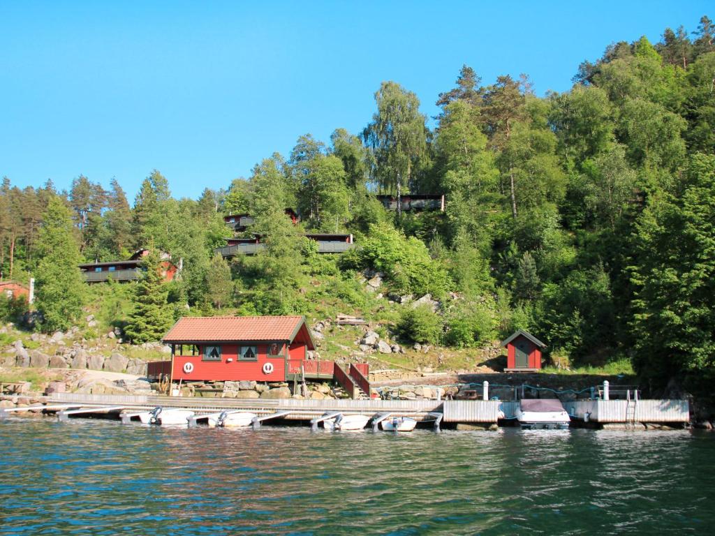 a red house on the side of a river at Holiday Home Haugen - SOW044 by Interhome in Lyngdal