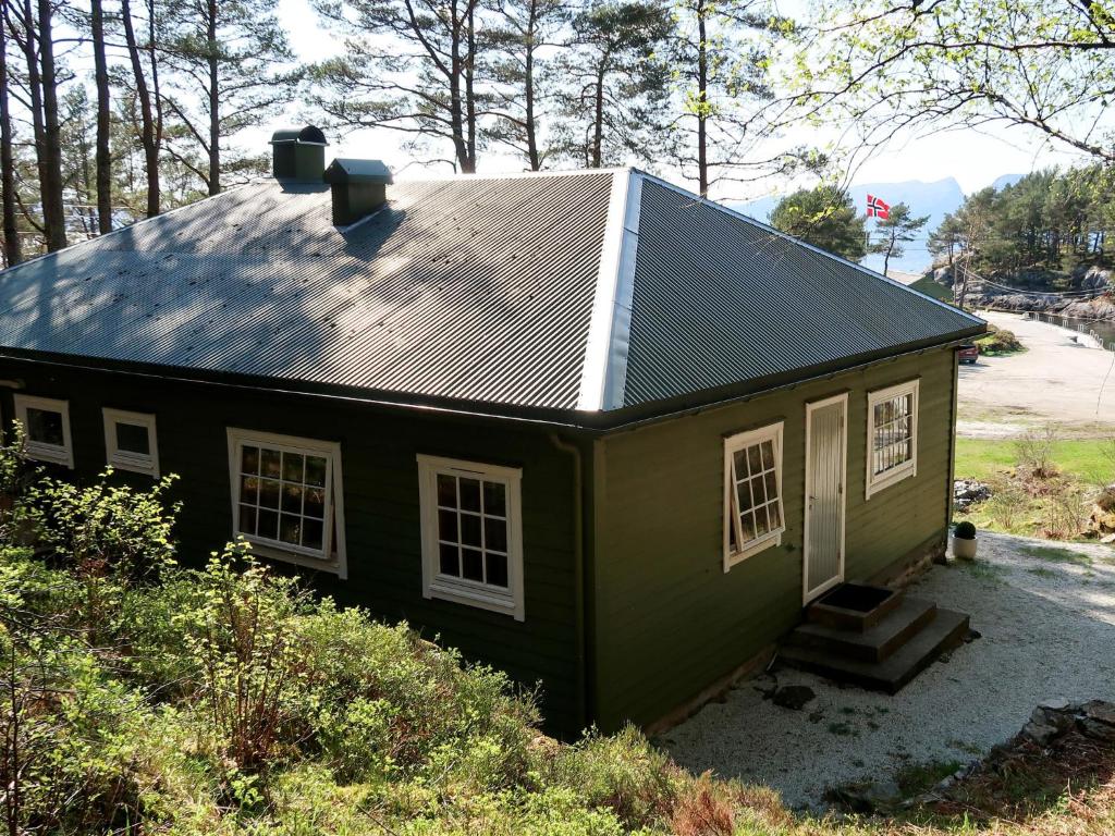 una pequeña casa verde con techo de estaño en Holiday Home Solsvika - FJS125 by Interhome, en Leirvik