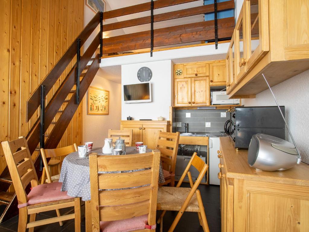 a kitchen with a table and chairs and a staircase at Apartment Les Asters-1 by Interhome in Les Menuires