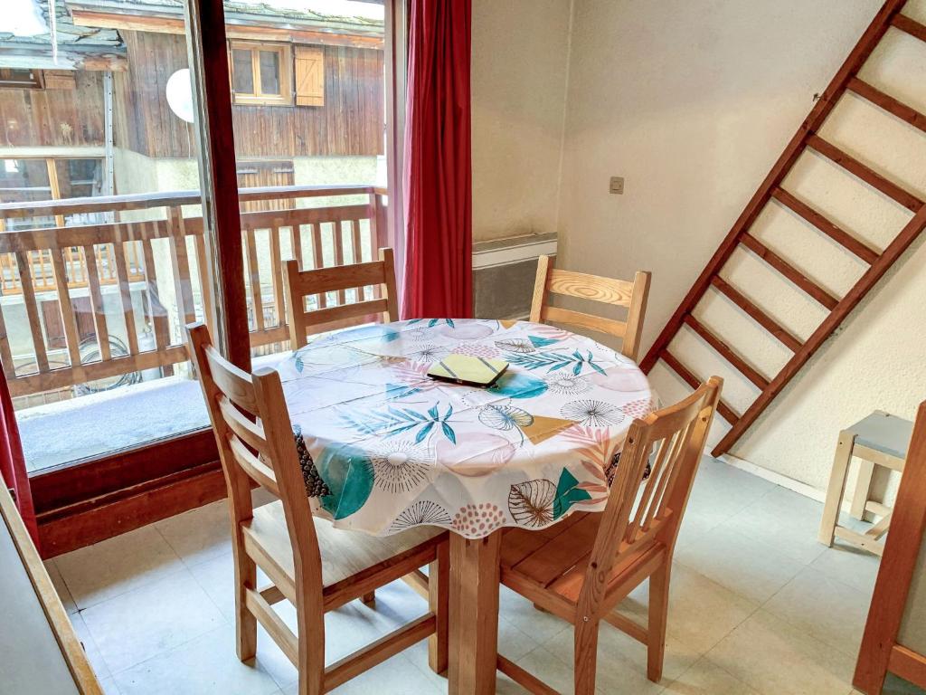 a dining room table with two chairs and a window at Apartment Les Olympiques - Tignes 1800-7 by Interhome in Les Boisses