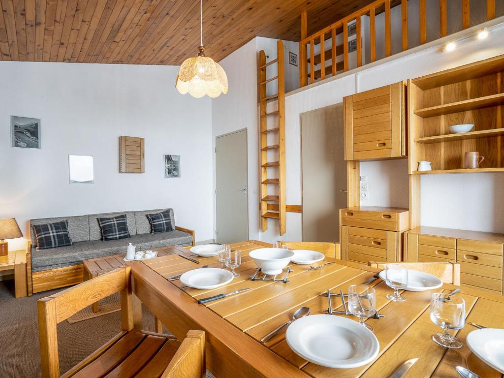 a dining room with a wooden table with plates on it at Apartment Le Jettay-13 by Interhome in Les Menuires