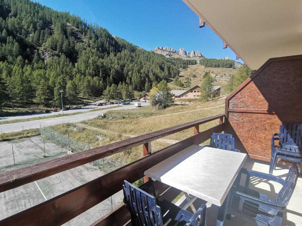 a balcony with a table and chairs and a mountain at Boost Your Immo Gardette Réallon A11 in Réallon