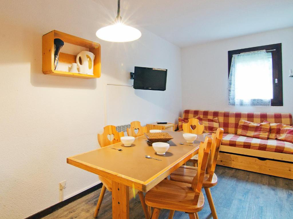 een woonkamer met een houten tafel en een bank bij Apartment Le Villaret-2 by Interhome in Les Menuires