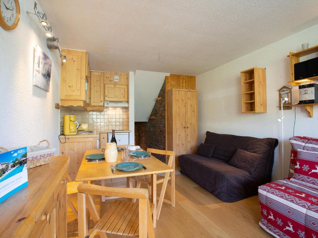 uma sala de estar com uma mesa e um sofá em Apartment Brelin-9 by Interhome em Les Menuires