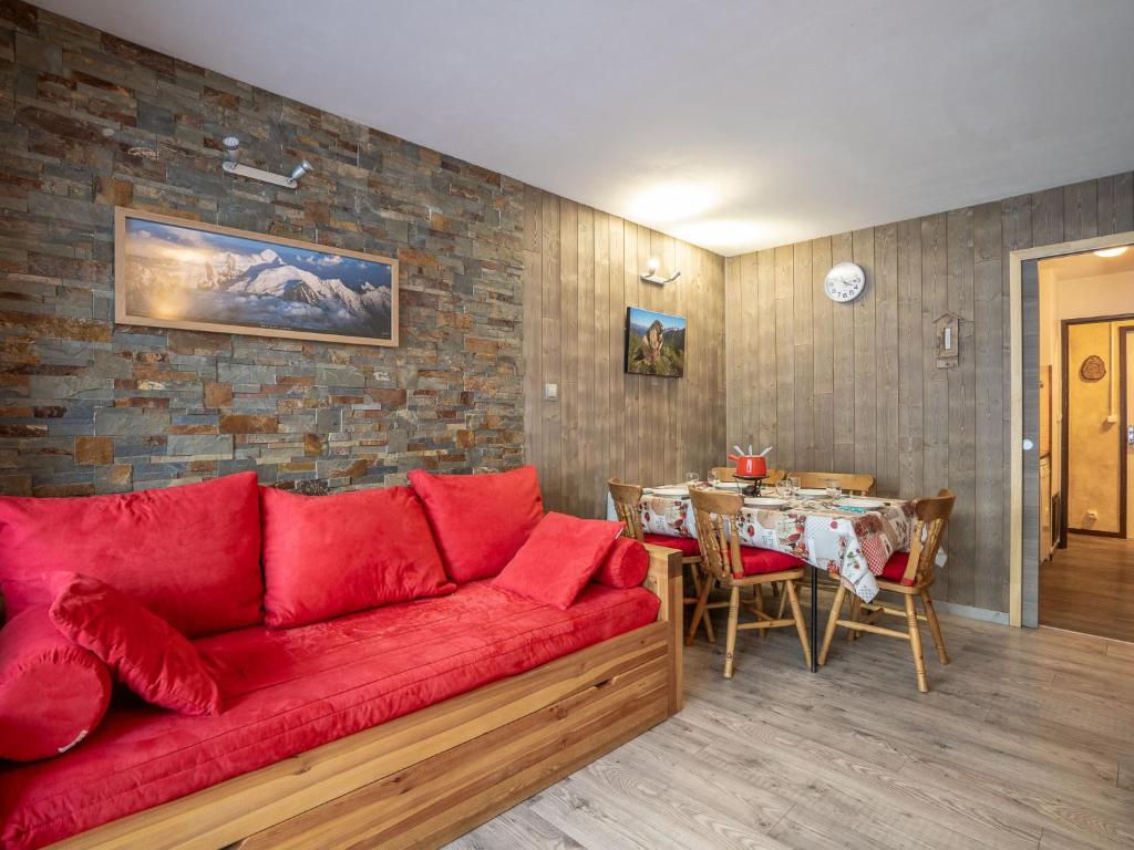 a living room with a red couch and a table at Apartment Les Burons-1 by Interhome in Les Menuires