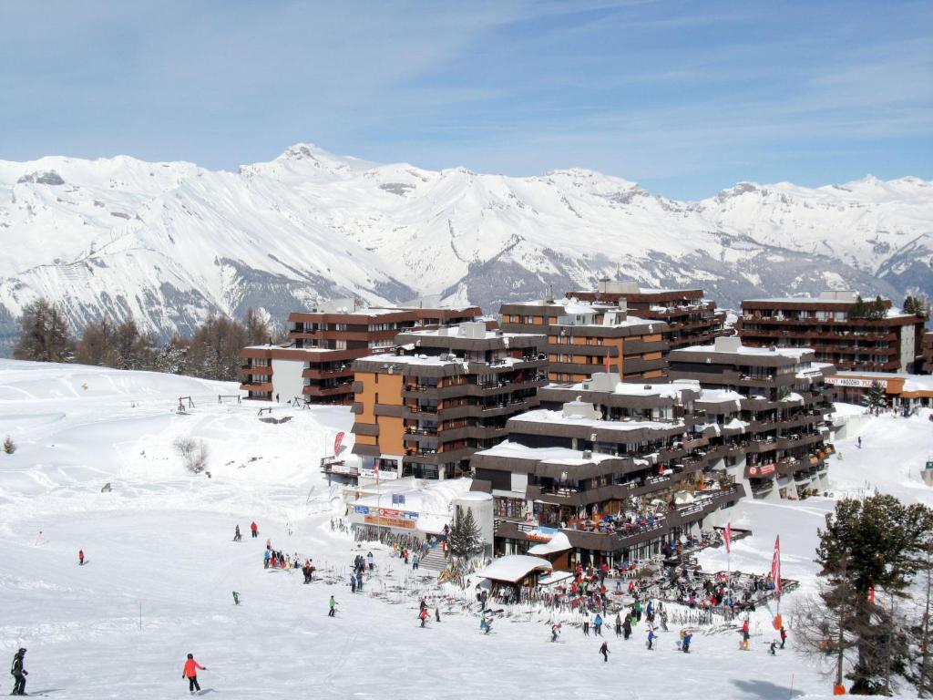un groupe de personnes dans la neige devant un lodge de ski dans l'établissement Apartment Essert 308 by Interhome, à Les Collons