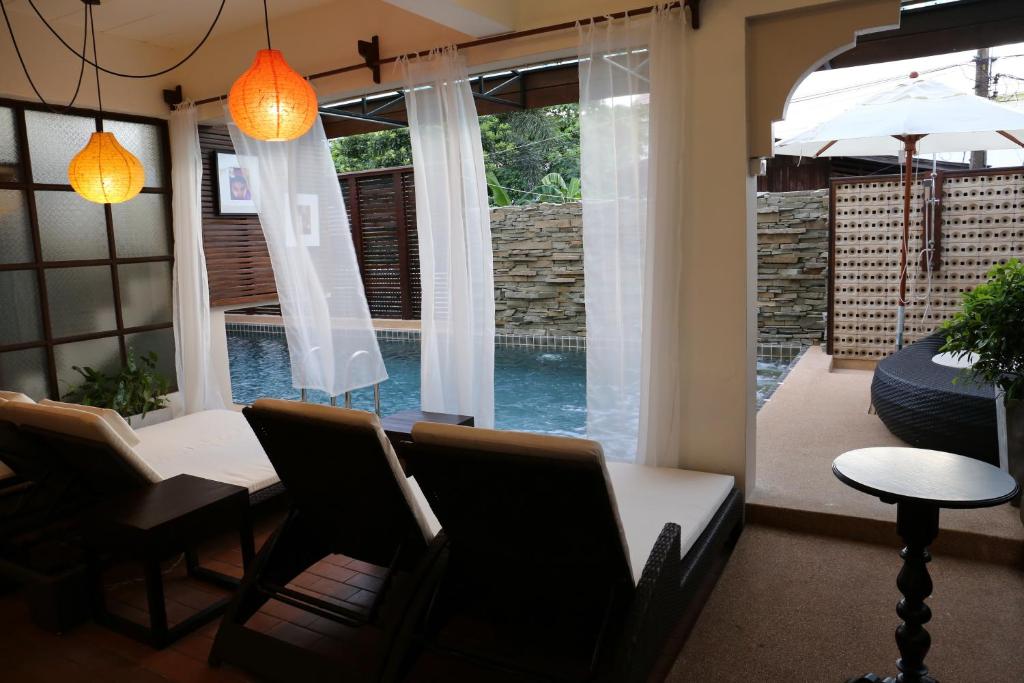uma sala de jantar com uma mesa e cadeiras e uma janela em Kampaeng Ngam Hotel - SHA Extra Plus em Chiang Mai