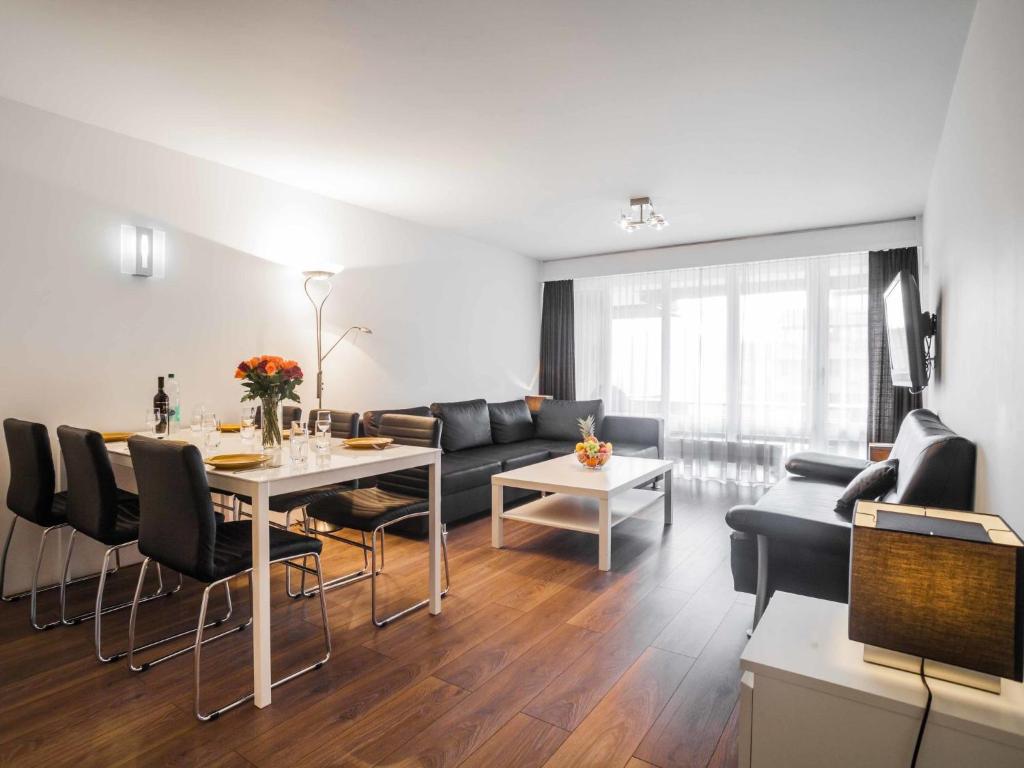 uma sala de estar com um sofá, uma mesa e cadeiras em Apartment Wildhorn 222 by Interhome em Les Collons