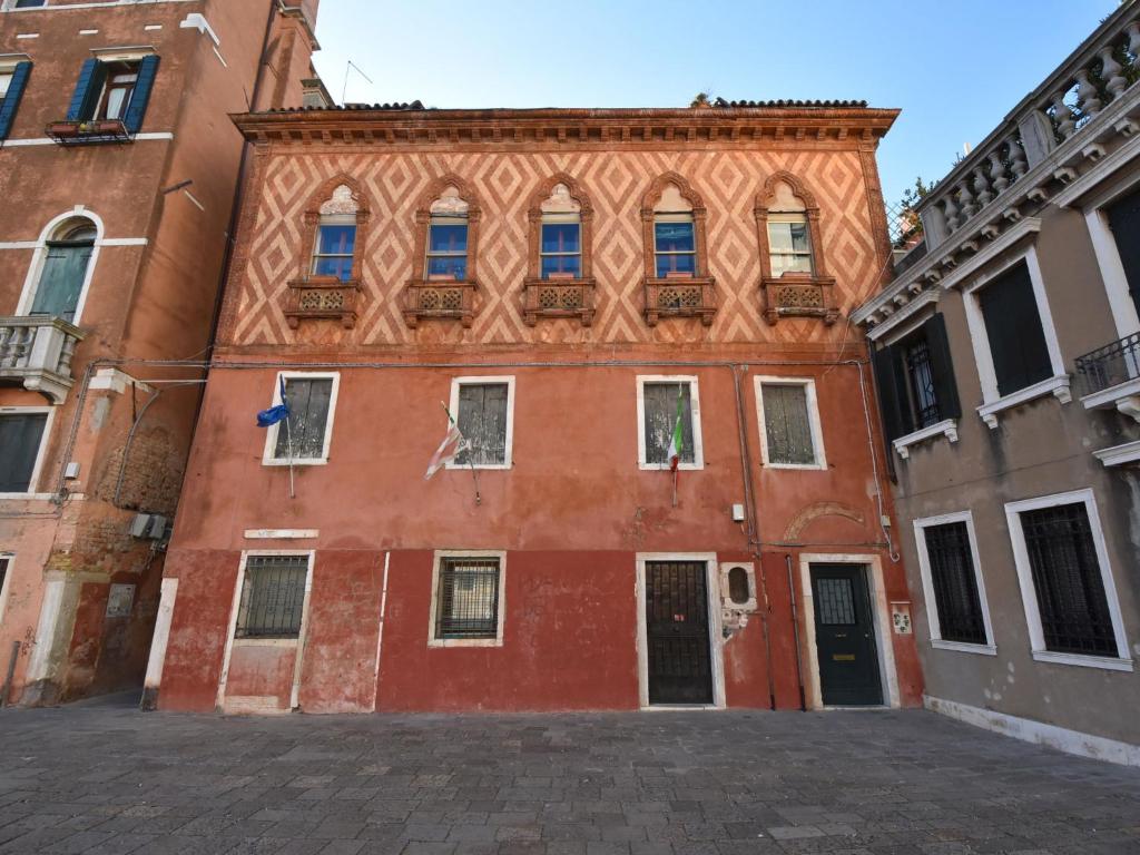 ヴェネツィアにあるApartment Campo Santa Maria Formosa by Interhomeの通りに窓のある大きな赤い建物