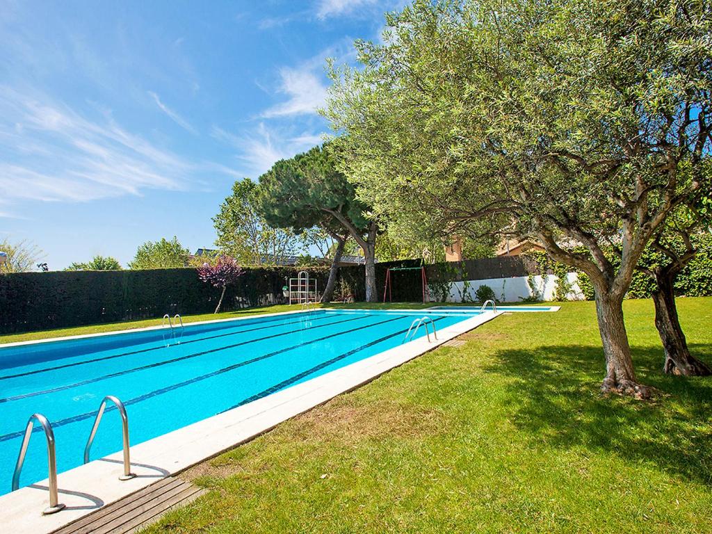 a large swimming pool in a yard with a tree at Apartment Edificio Blanqueries by Interhome in Calella