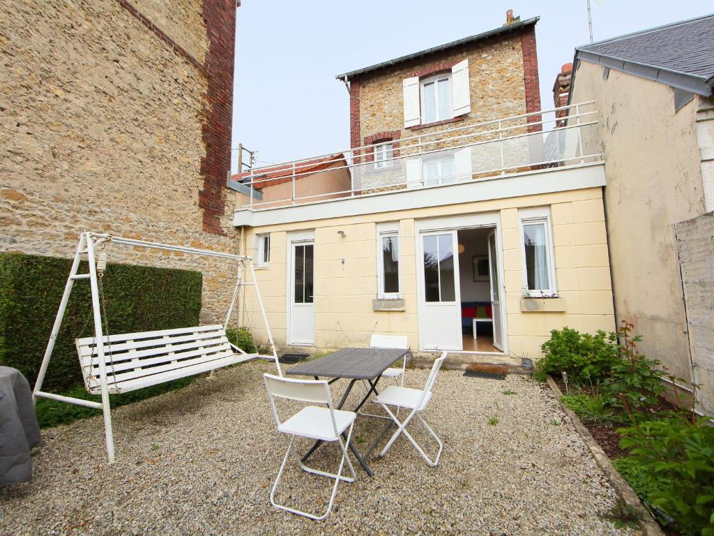 un patio con mesa, sillas y un columpio en Villa Villa by Interhome en Villers-sur-Mer