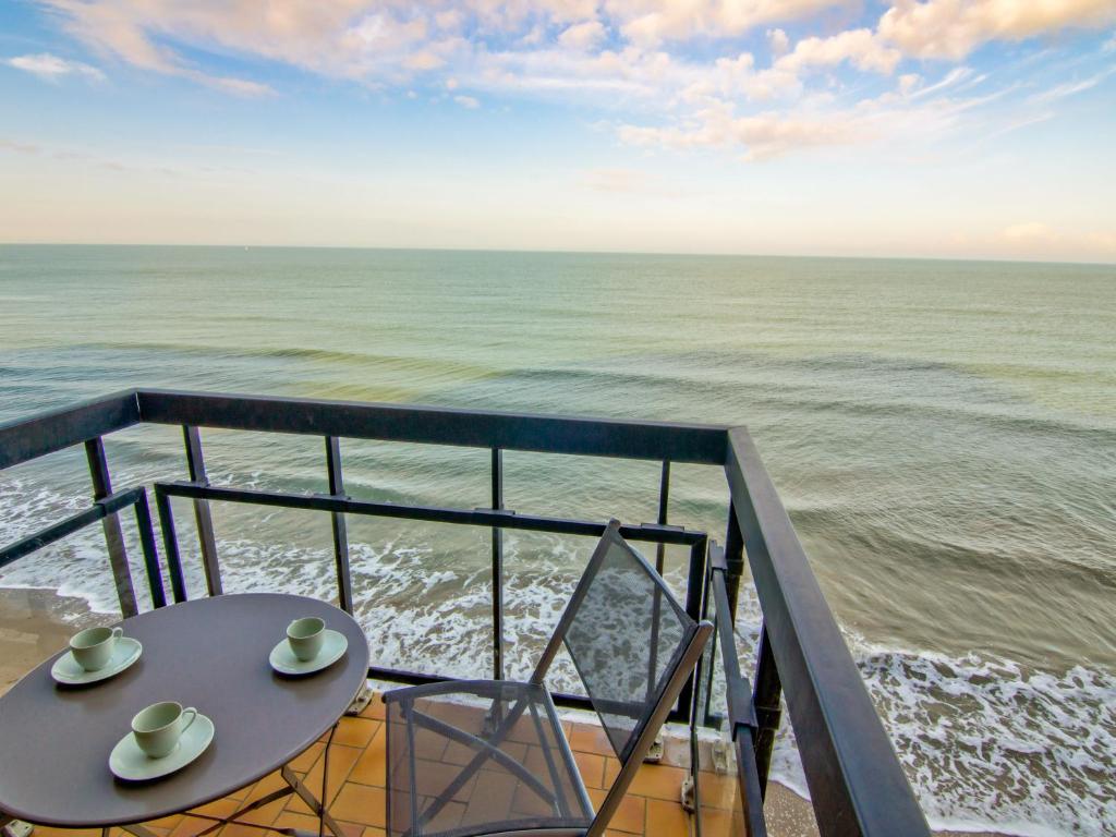a table and chairs on a balcony overlooking the ocean at Apartment Les Flots-2 by Interhome in Trouville-sur-Mer