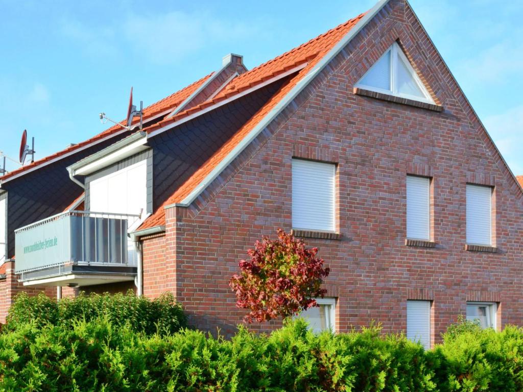 a red brick house with a gambrel roof at Apartment Seestern by Interhome in Norddeich