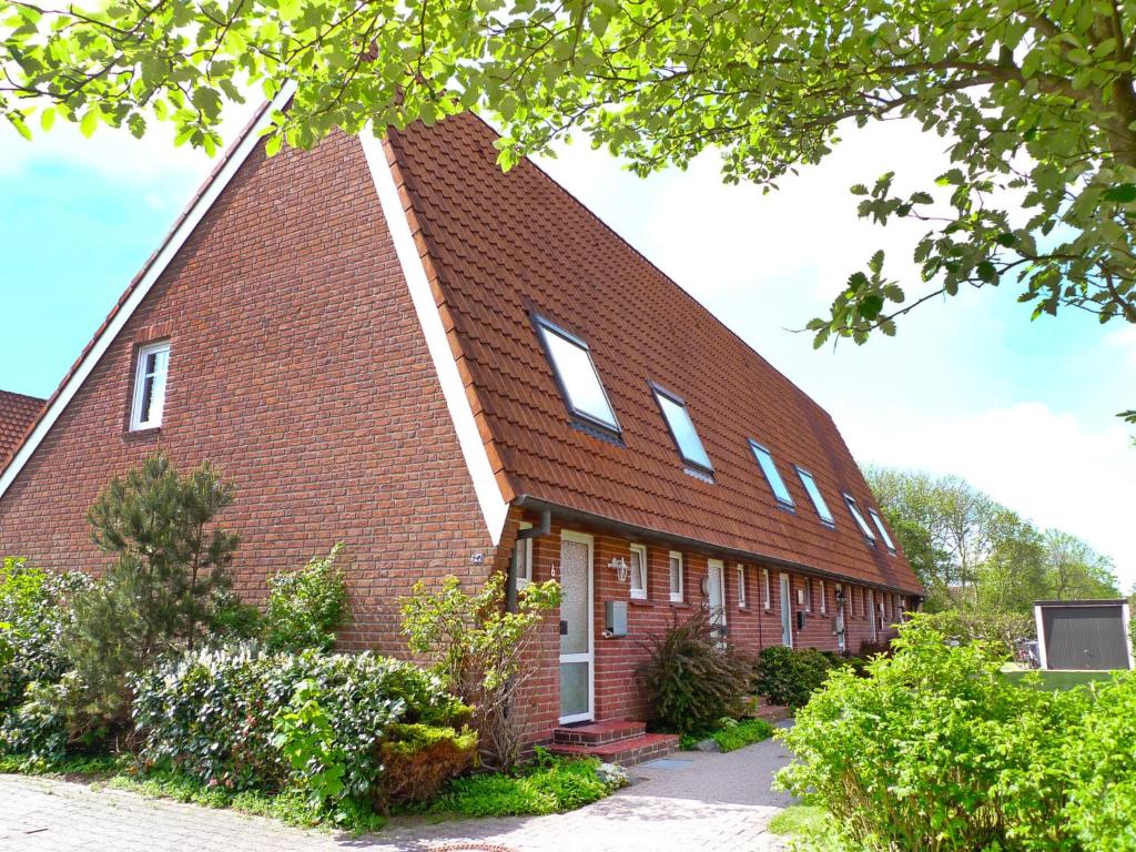 een rood bakstenen gebouw met een gambrel dak bij Holiday Home Müter by Interhome in Norddeich