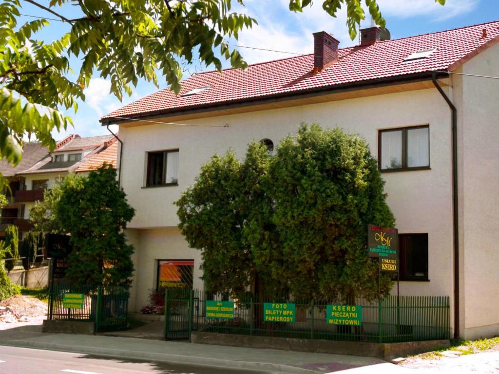 Una casa blanca con un árbol delante. en Apartment Królowej Jadwigi by Interhome, en Cracovia