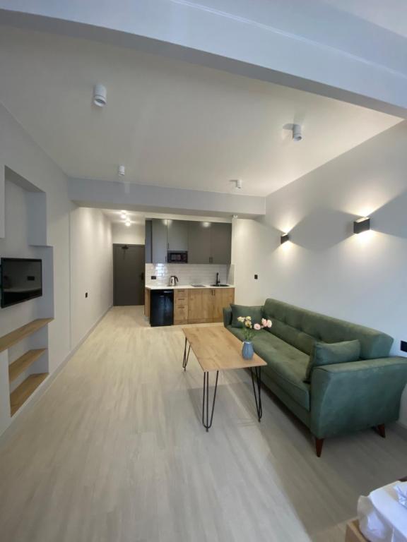 a living room with a green couch and a table at Апарт-отель Nine Rooms in Yerevan