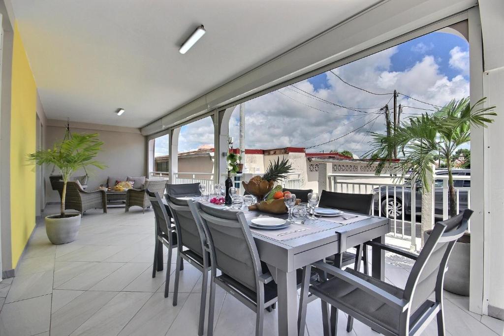 a dining room with a table and chairs on a balcony at Villa Perle Dor in Sainte-Anne