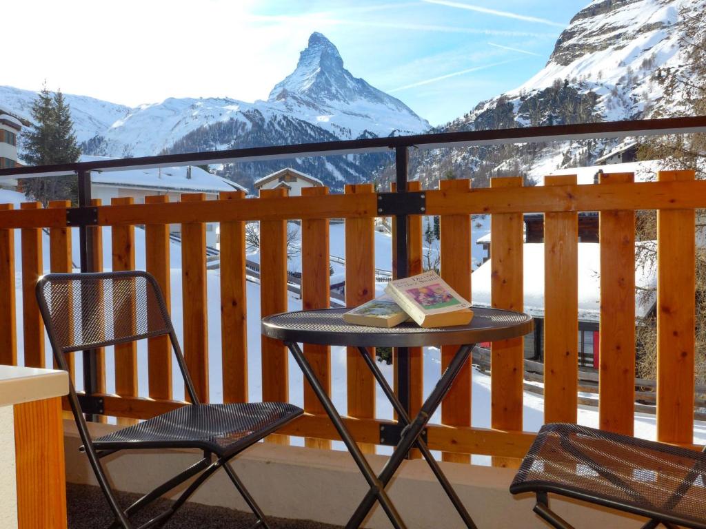 una mesa y una silla en un balcón con una montaña en Studio Silence-4 by Interhome, en Zermatt